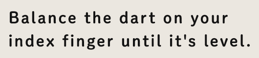 Balance the dart on your index finger until it's level.