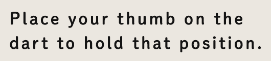 Place your thumb on the dart to hold that position.